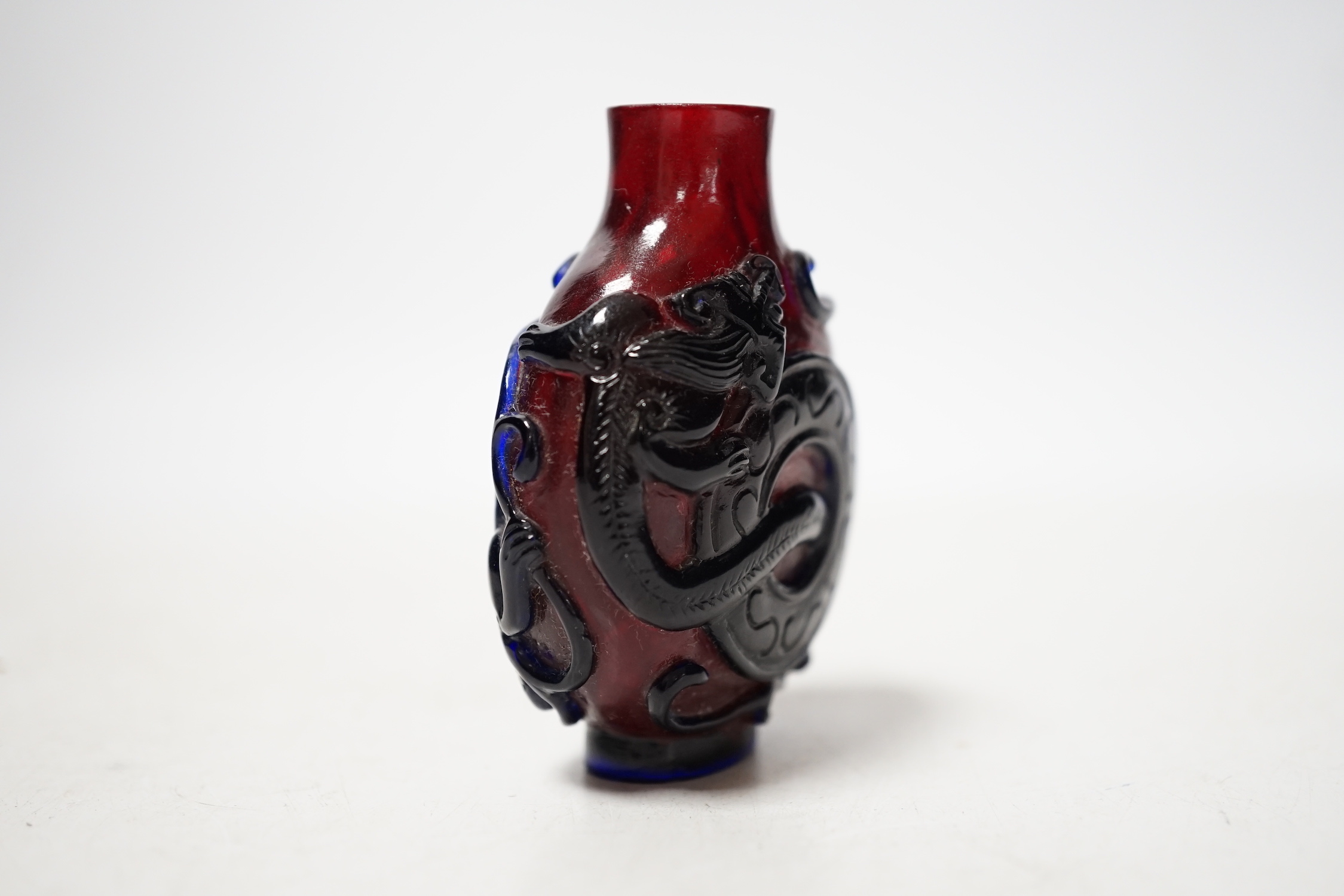 A Chinese amethyst and ruby glass ‘dragon’ snuff bottle, 19th century, 6cm high